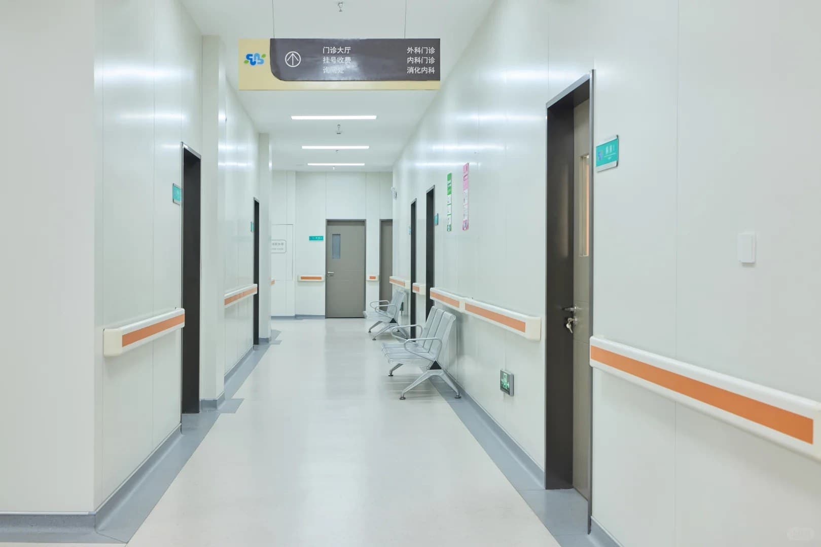 Corridor of hospital outpatient department with direction signs and waiting seats