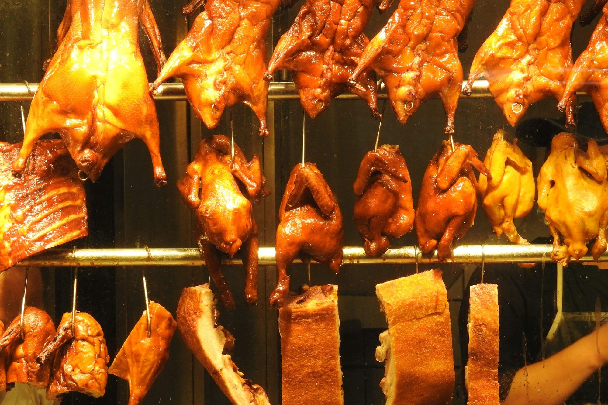 Aufgehängte Gänse, Enten und gebratenes Schweinefleisch in einem Guangzhou-Siu-Mei-Laden