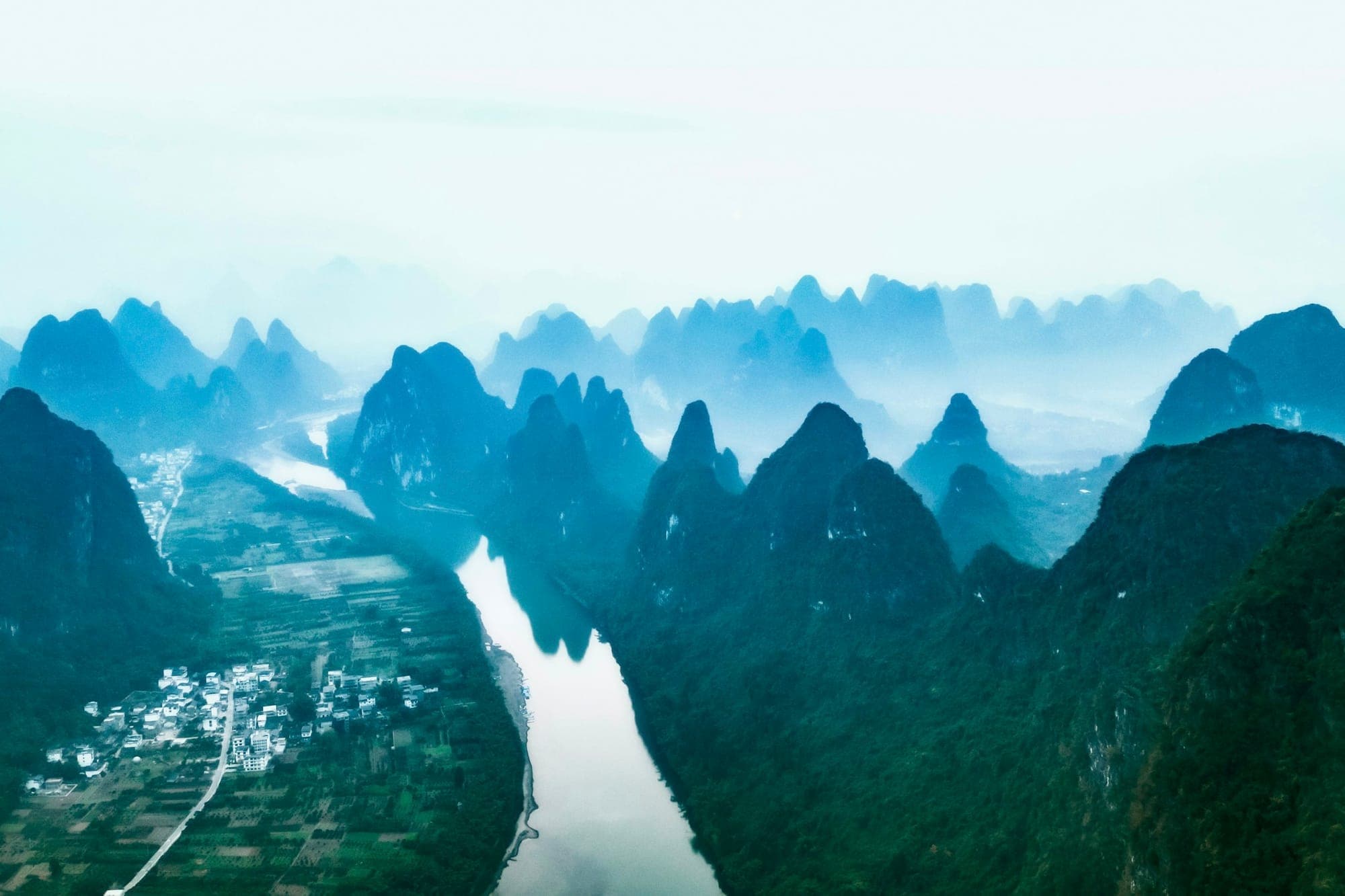 Der Li-Fluss schlängelt sich aus der Vogelperspektive zwischen den Karstgipfeln bei Guilin
