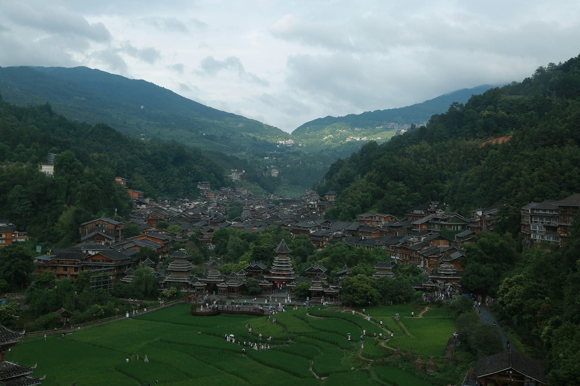 Miao-Dorf mit Holzhäusern in einem grünen Tal, Qiandongnan, Guizhou