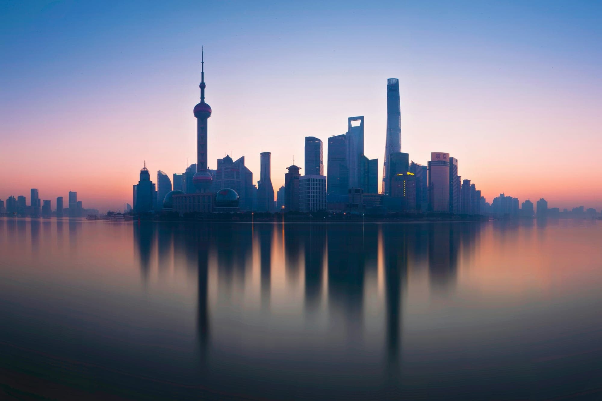 Die Skyline von Shanghais Lujiazui spiegelt sich im Huangpu-Fluss bei Tagesanbruch