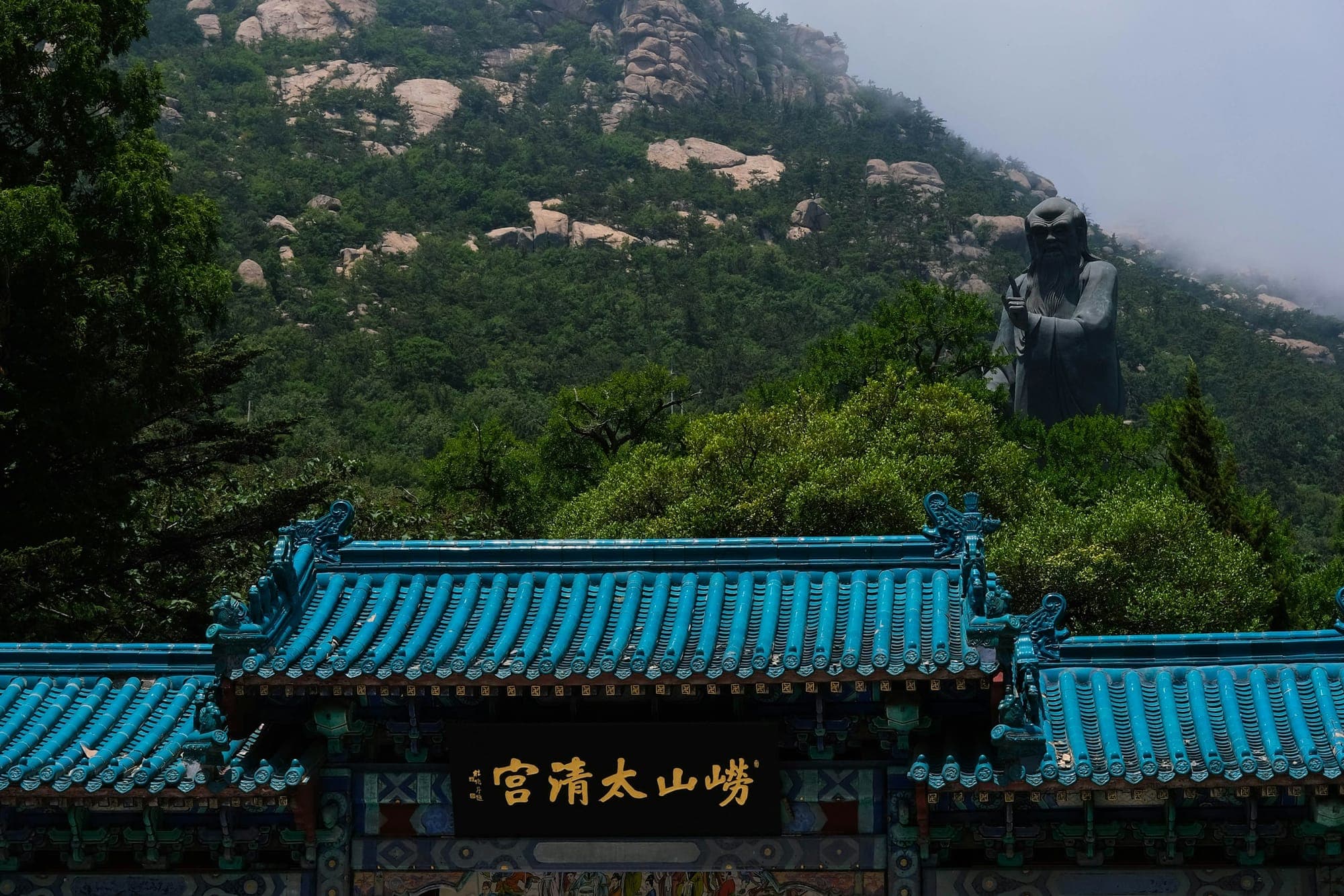 La porta del Palazzo Taiqing sotto i versanti granitici del Laoshan, Qingdao