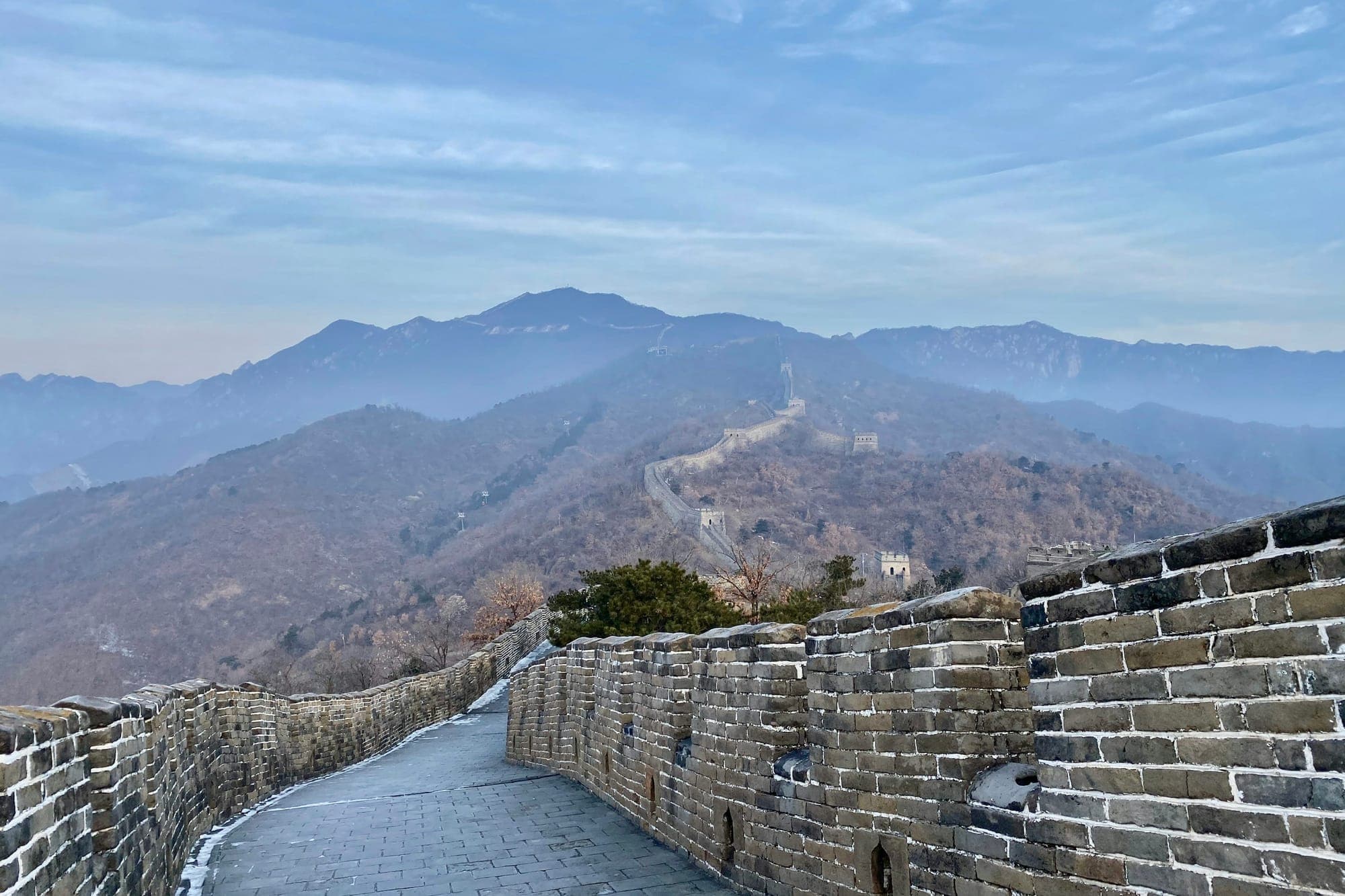 Weg der Chinesischen Mauer bei Mutianyu über dunstigen Bergrücken
