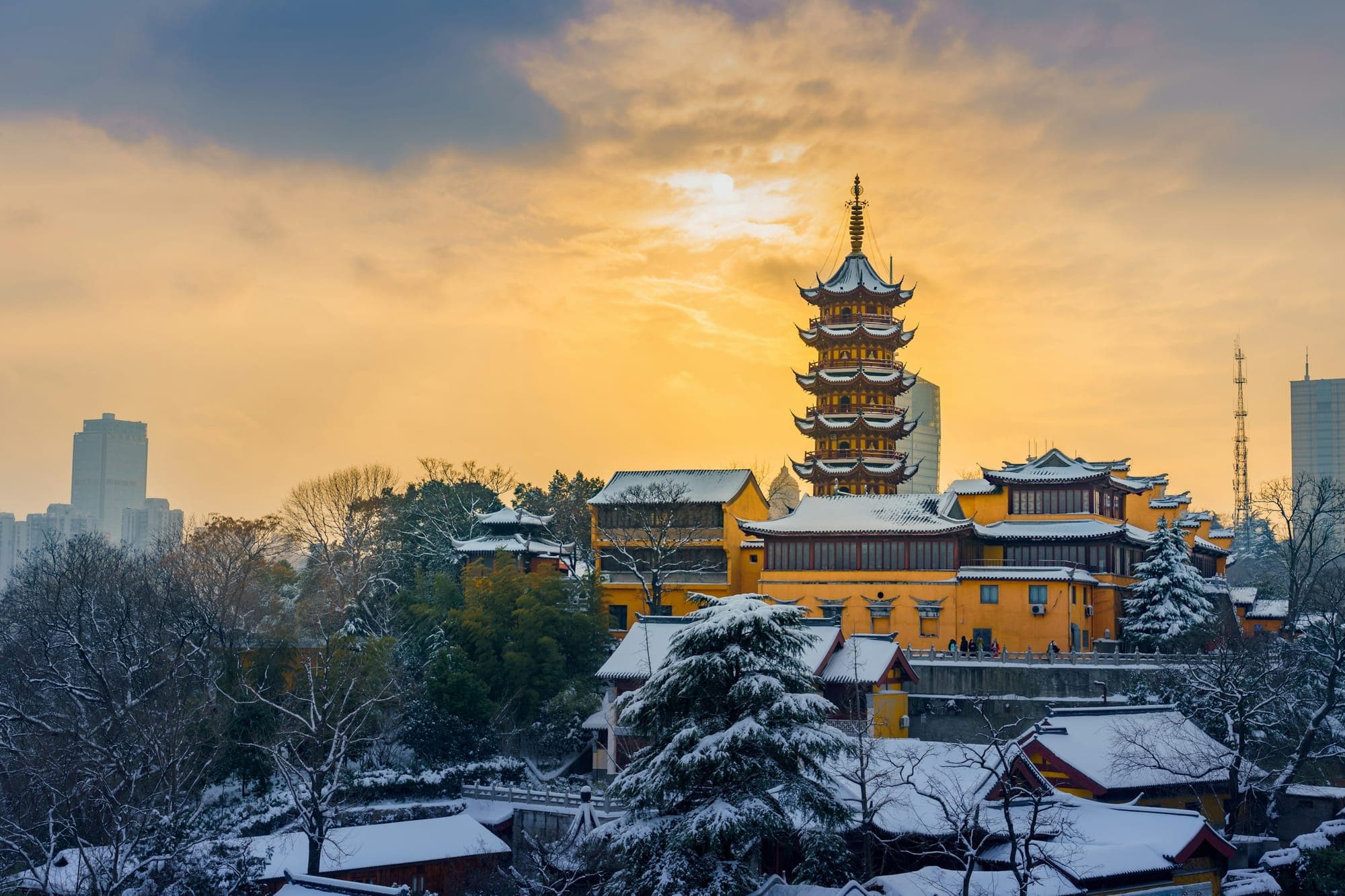 Pagoda del Tempio Jiming sopra i tetti innevati al tramonto, Nanjing