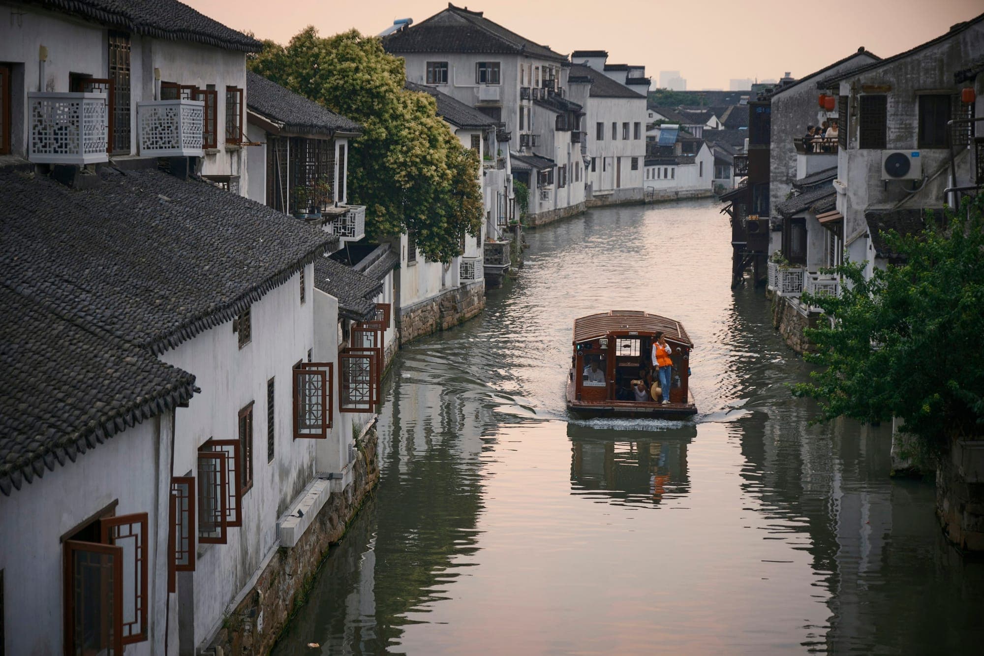Ein Boot auf einem Kanal zwischen Häusern mit weißen Wänden in der Shantang Street in Suzhou