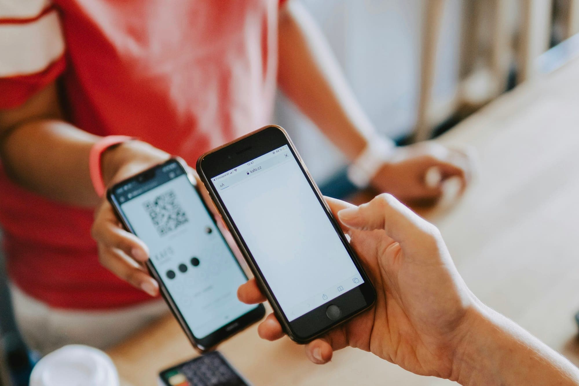 Ein Smartphone zeigt einen Zahlungs-QR-Code, während ein anderes Smartphone ihn scannt