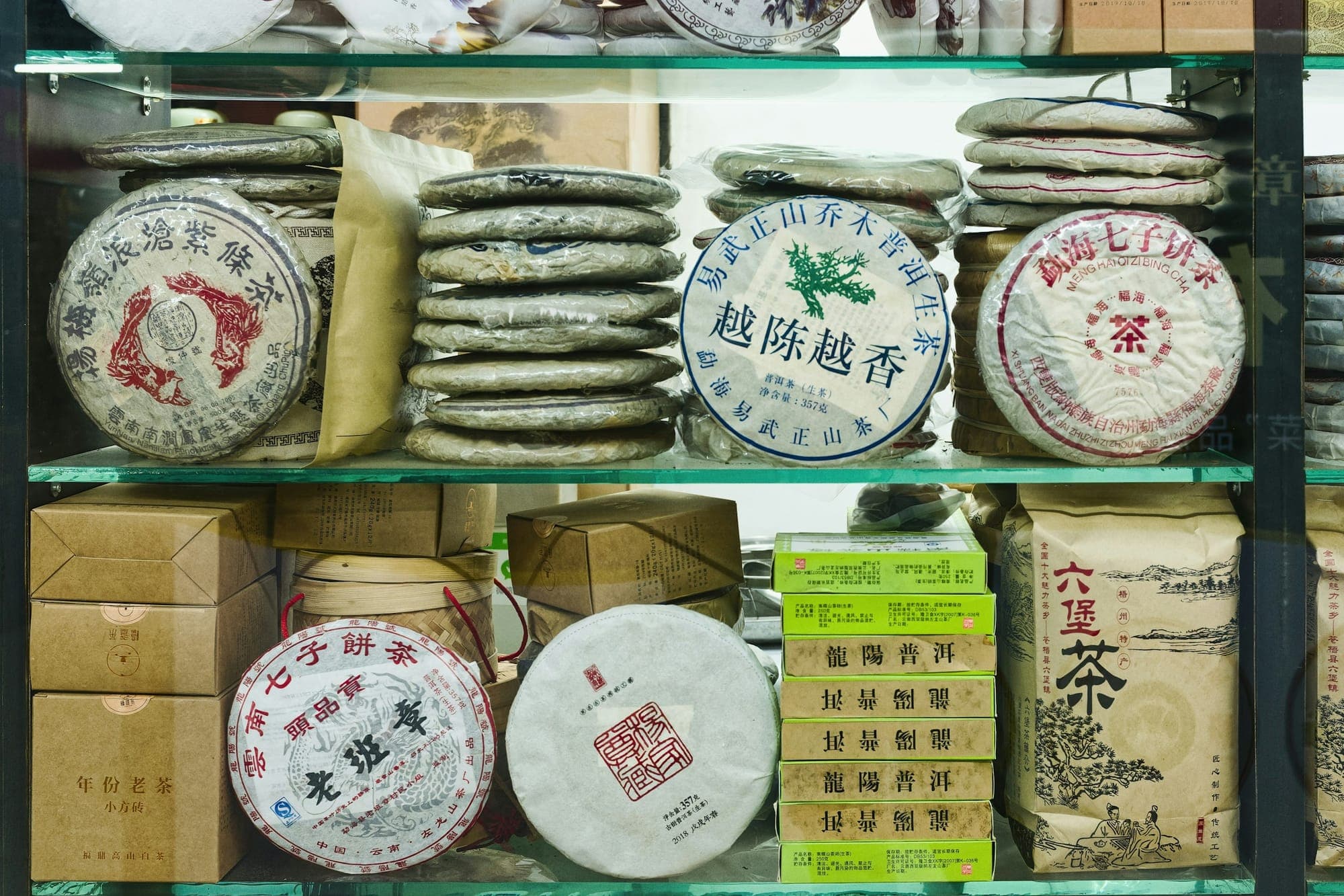 Galettes de thé Pu'er empilées sur les étagères d'une boutique de thé