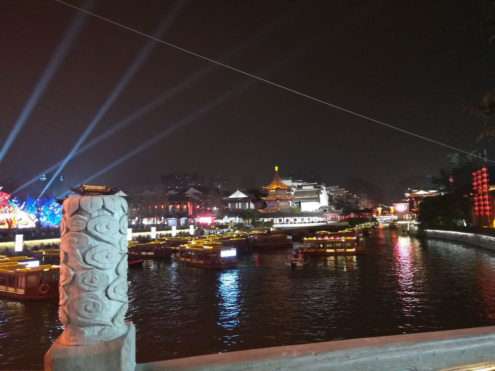 Laternenausstellungen und Ausflugsboote auf einem Fluss bei Nacht während eines chinesischen Laternenfestes