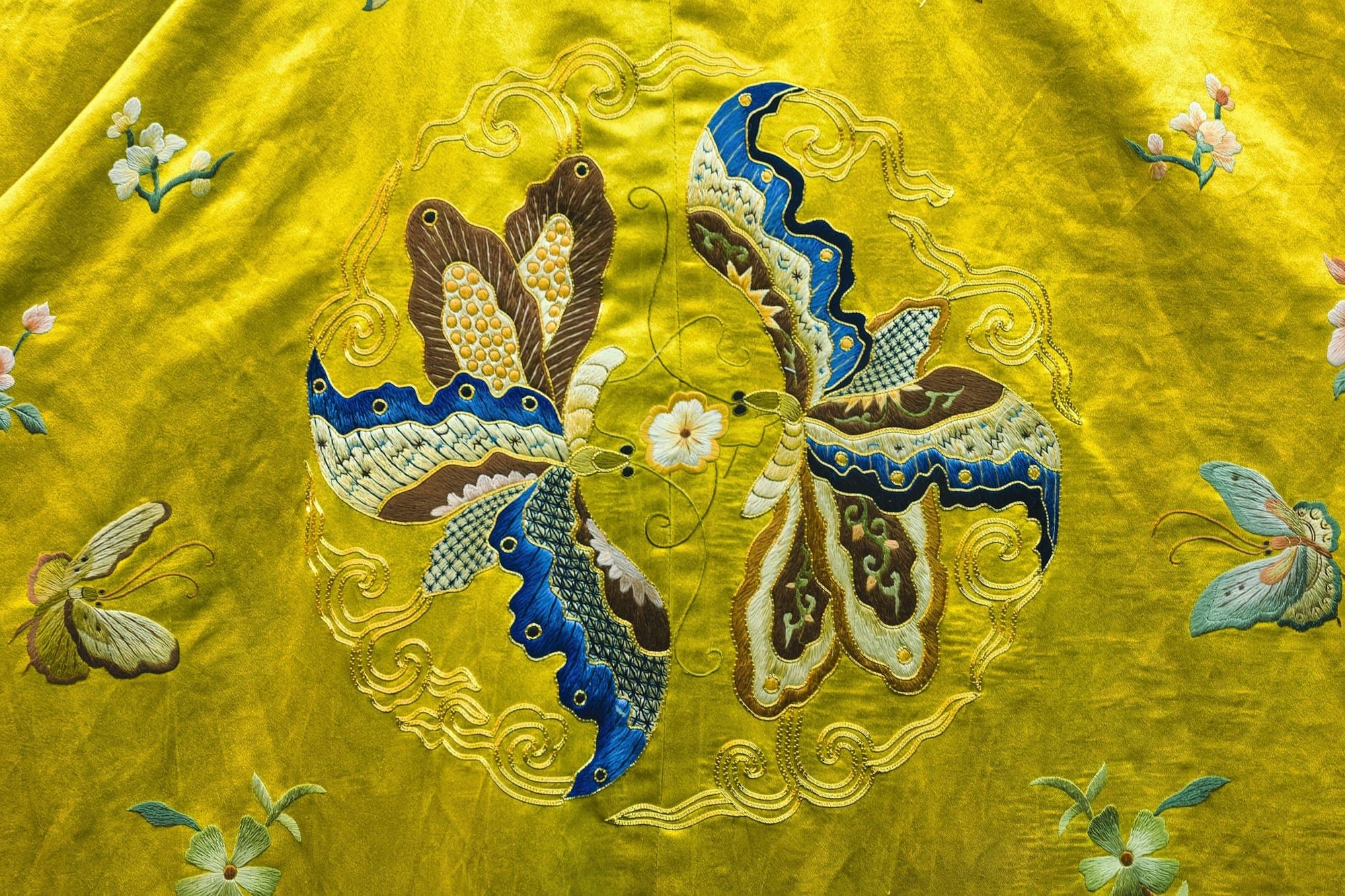 Papillons brodés en soie sur un fond jaune