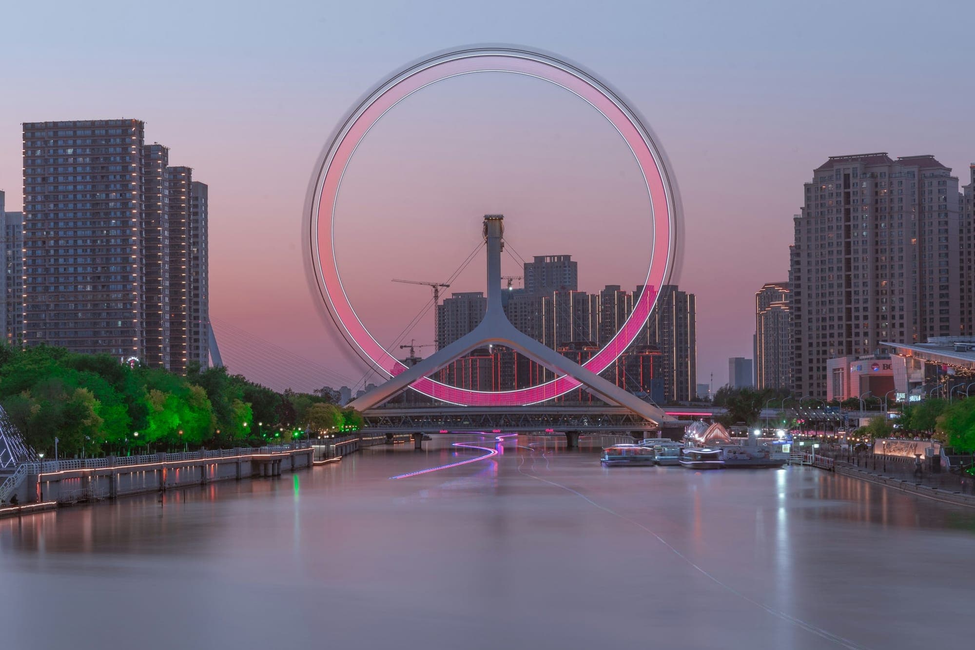 La noria Tianjin Eye sobre el río Hai al anochecer