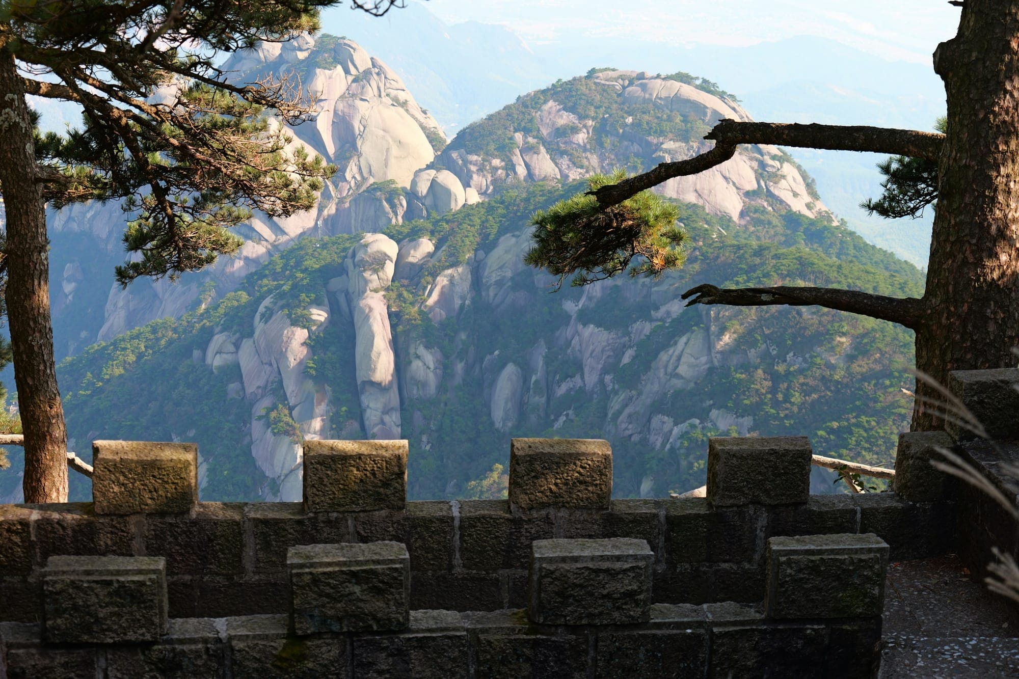 Cumbres de granito de la montaña Tianzhu vistas tras pinos y un parapeto de piedra, Anhui