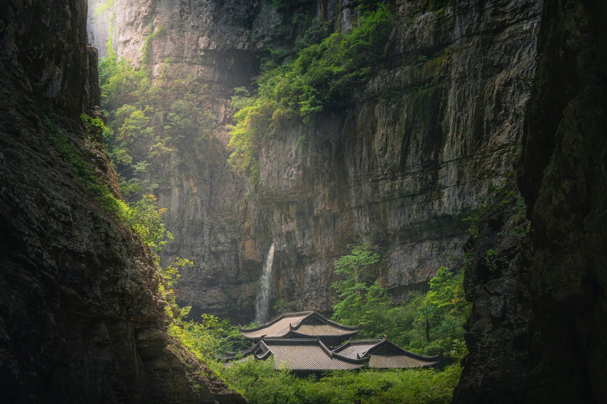 Talboden mit alten Gebäuden unter Karstklippen in Wulong, Chongqing