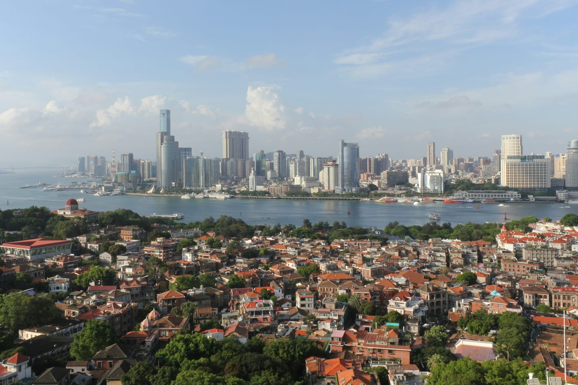 Los tejados rojos de Gulangyu con el horizonte urbano de Xiamen al otro lado del agua