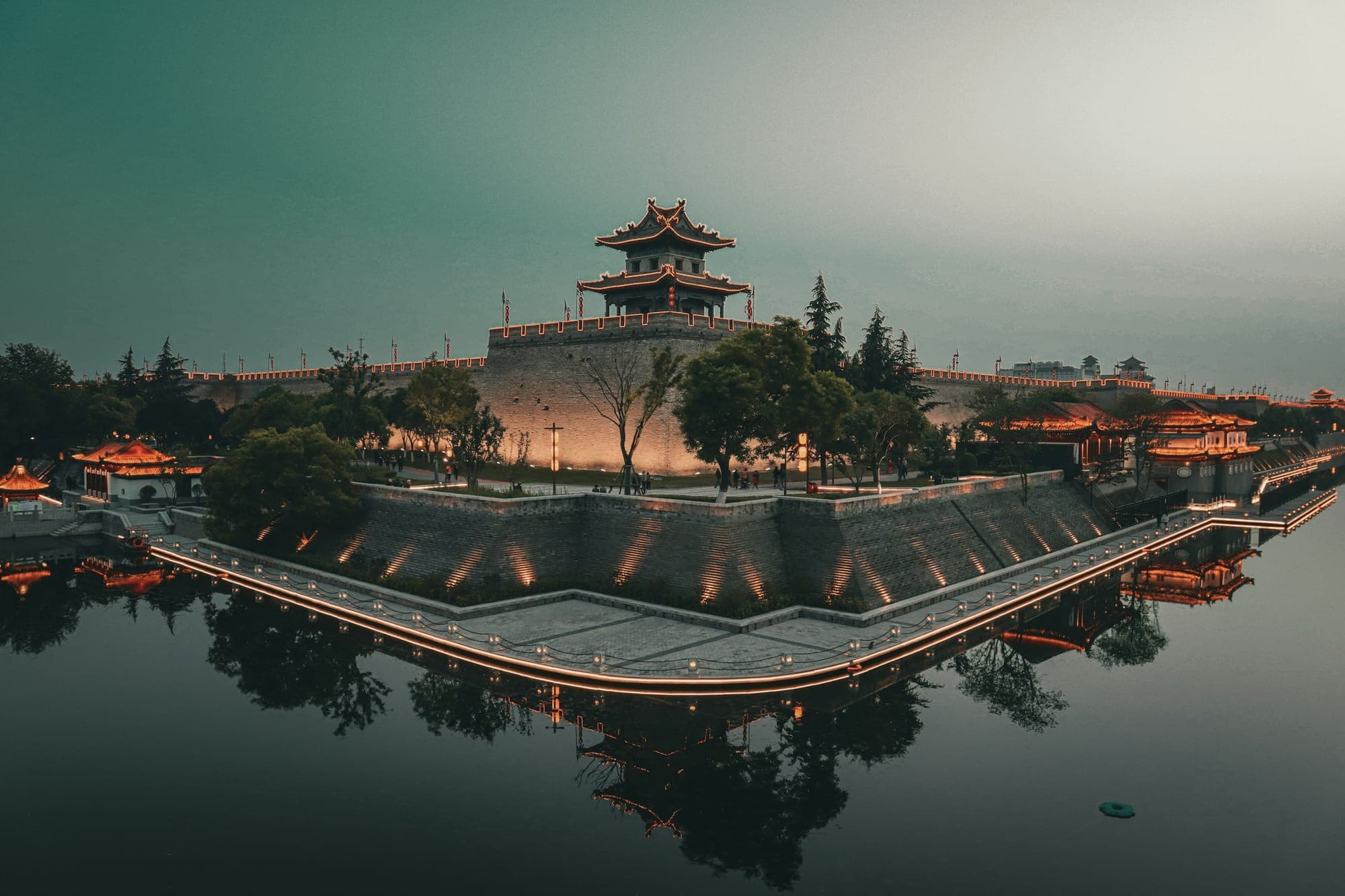 Una torre d'angolo delle mura di Xi'an riflessa nel fossato al crepuscolo
