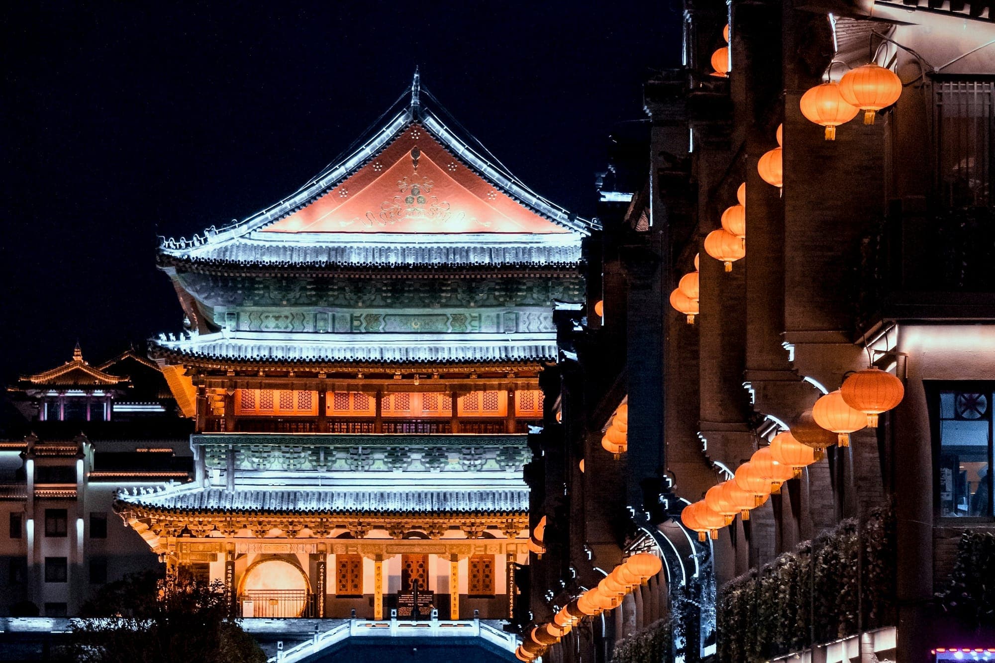 Der Trommelturm in Xi'an bei Nacht, mit Laternen entlang der benachbarten Straße