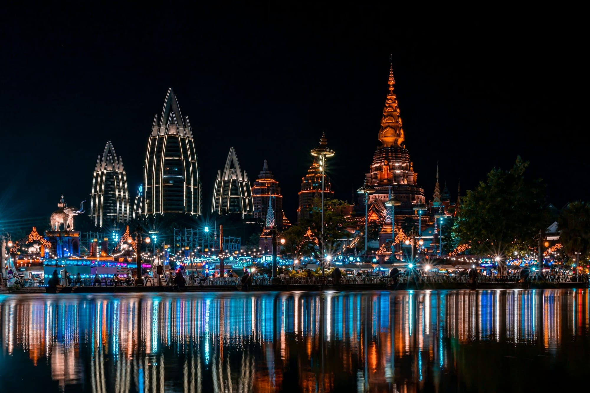 Guglie di templi in stile Dai illuminate e riflesse di notte, Xishuangbanna