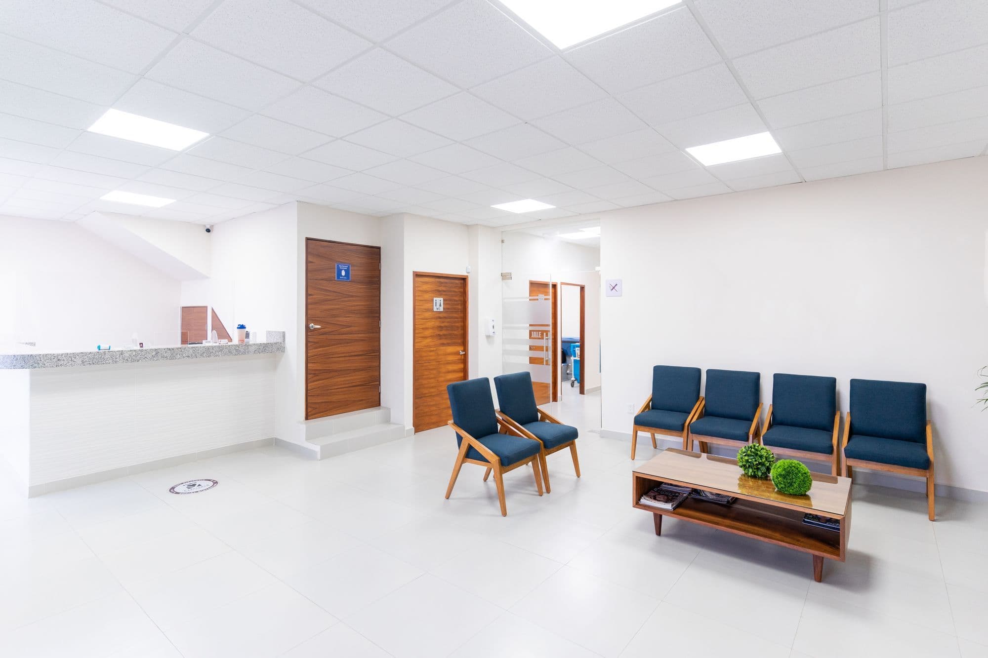 Accueil lumineux et calme d'une clinique, avec un comptoir et un espace d'attente