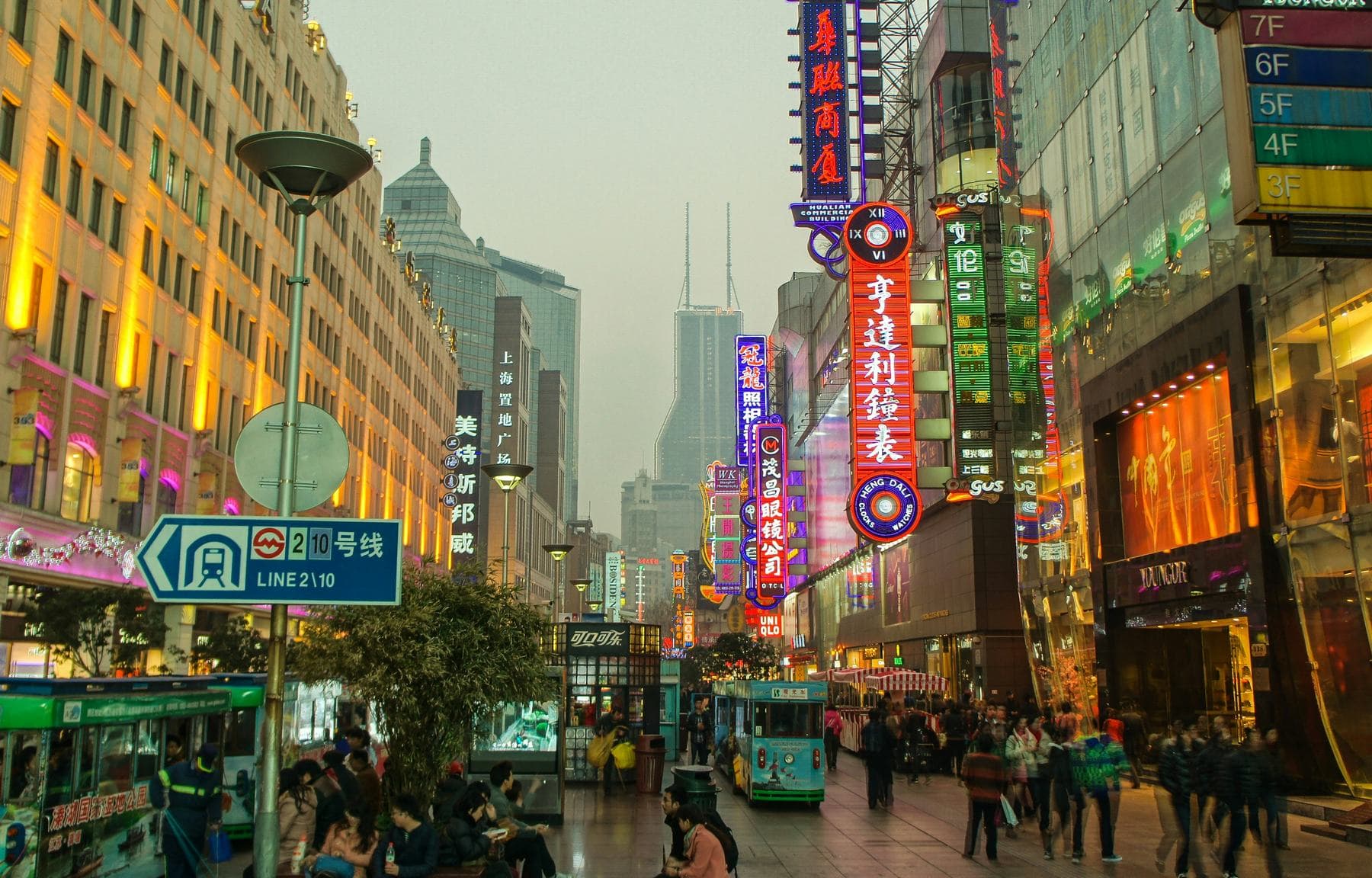 Acheteurs en soirée sur East Nanjing Road à Shanghai, sous les enseignes lumineuses des grands magasins