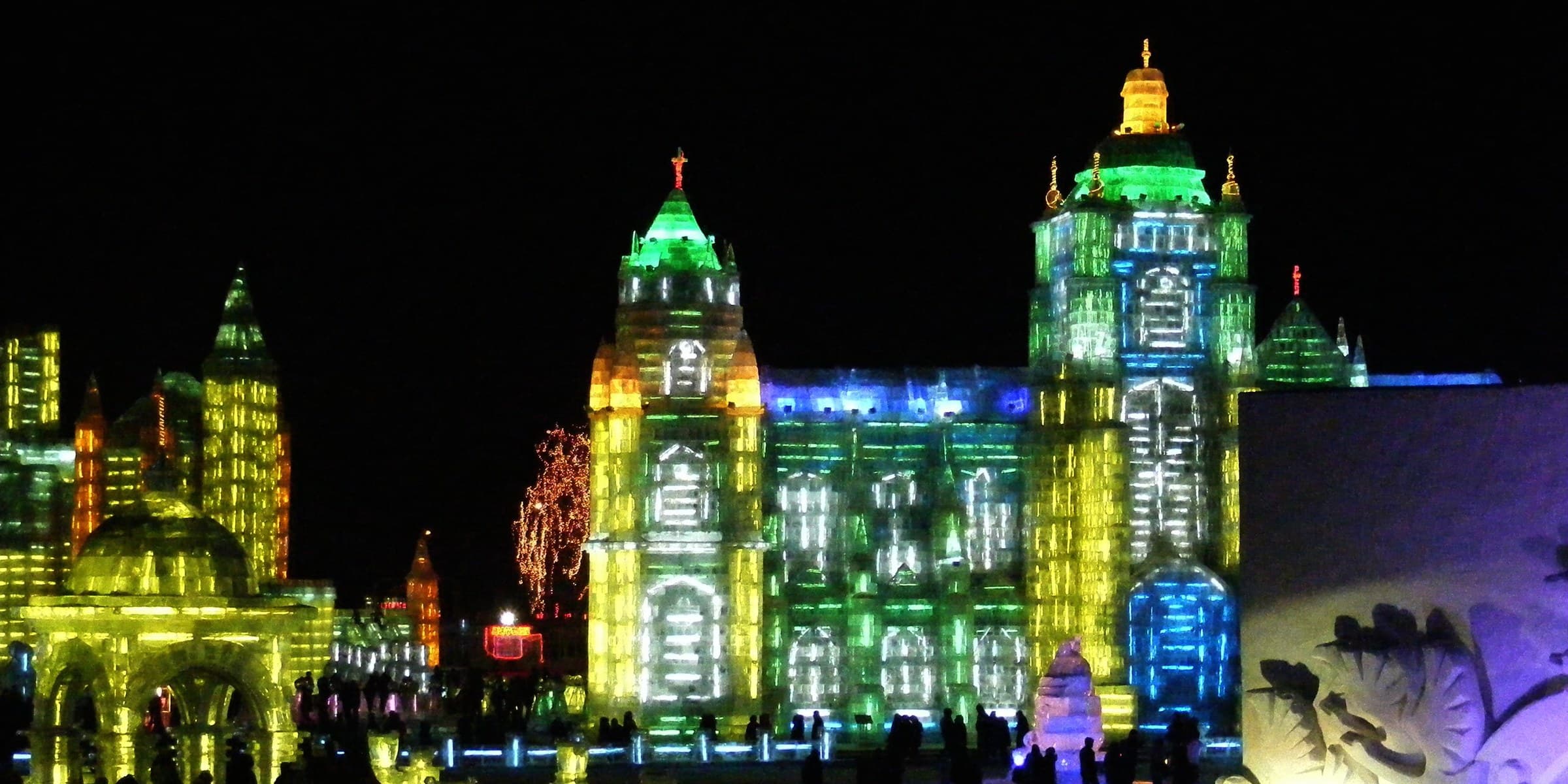 Sculture di palazzi di ghiaccio illuminate all'Harbin Ice and Snow World di notte