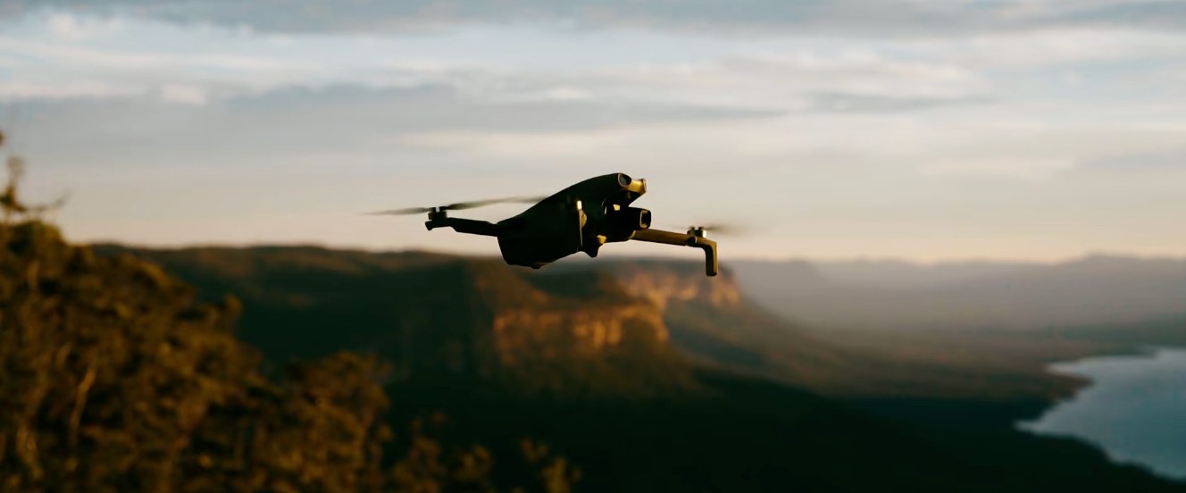 Drone flying over mountain valleys at golden hour
