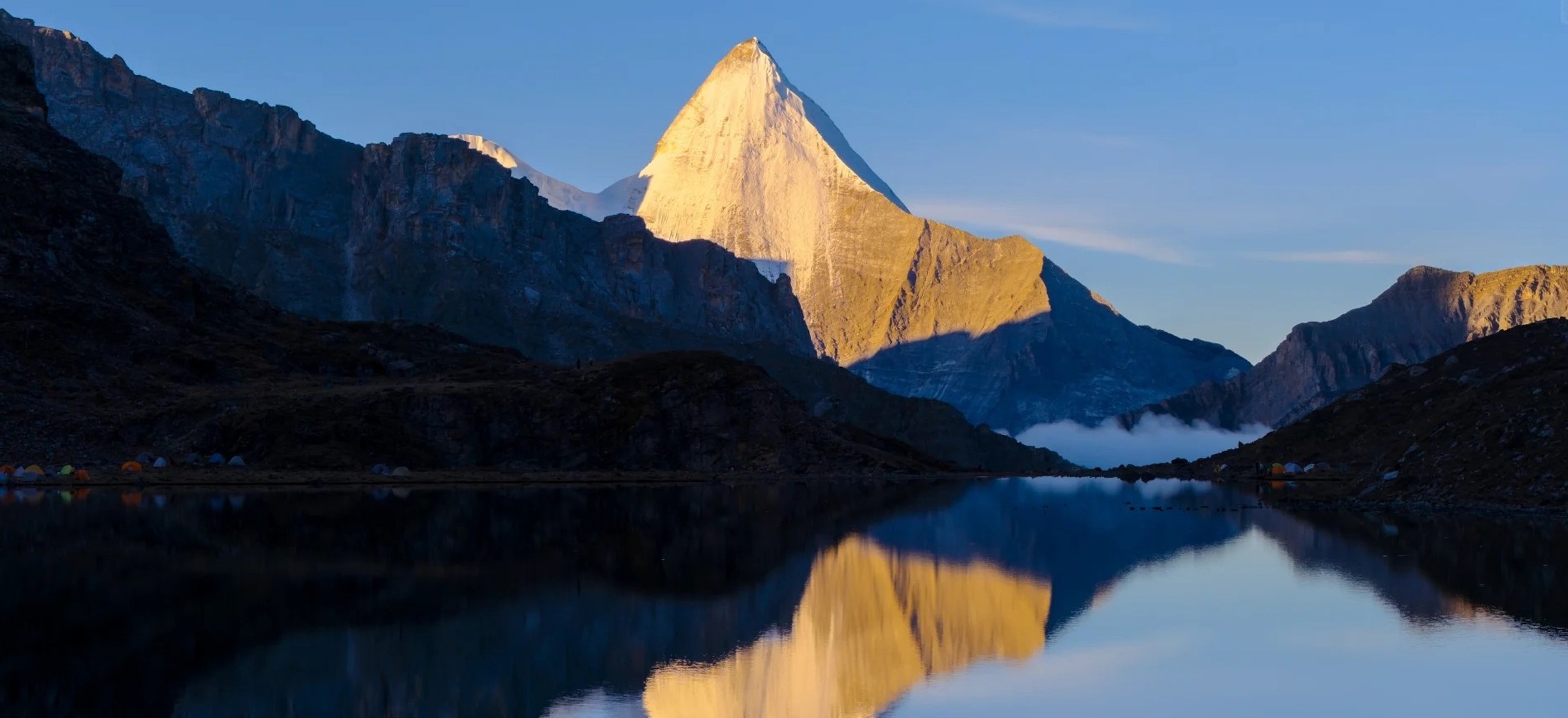 Yangmaiyong Peak with its reflection on the alpine lake at sunrise