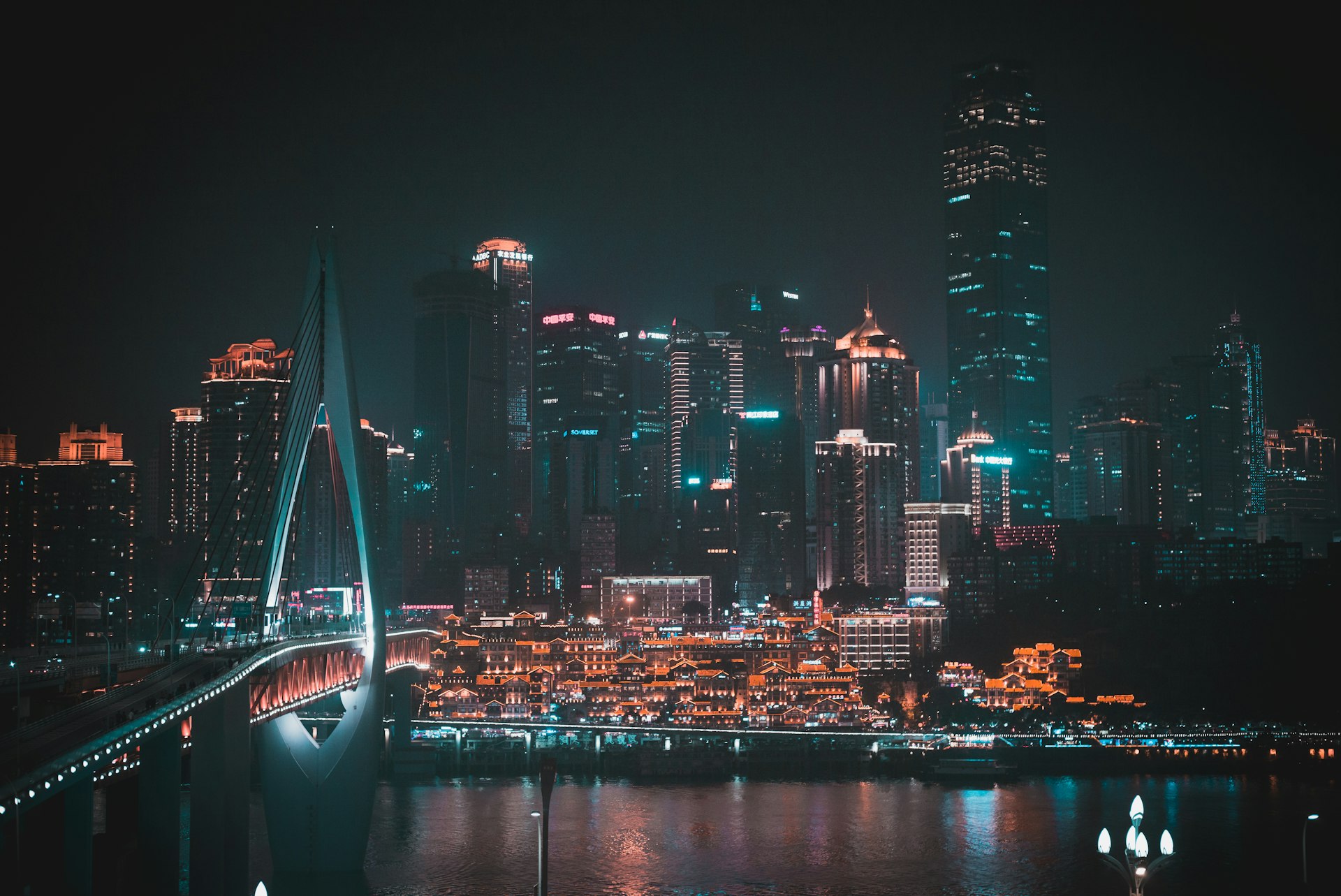 Hongyadong lit gold below the Yuzhong towers and Qiansimen Bridge across the Jialing River at night, Chongqing