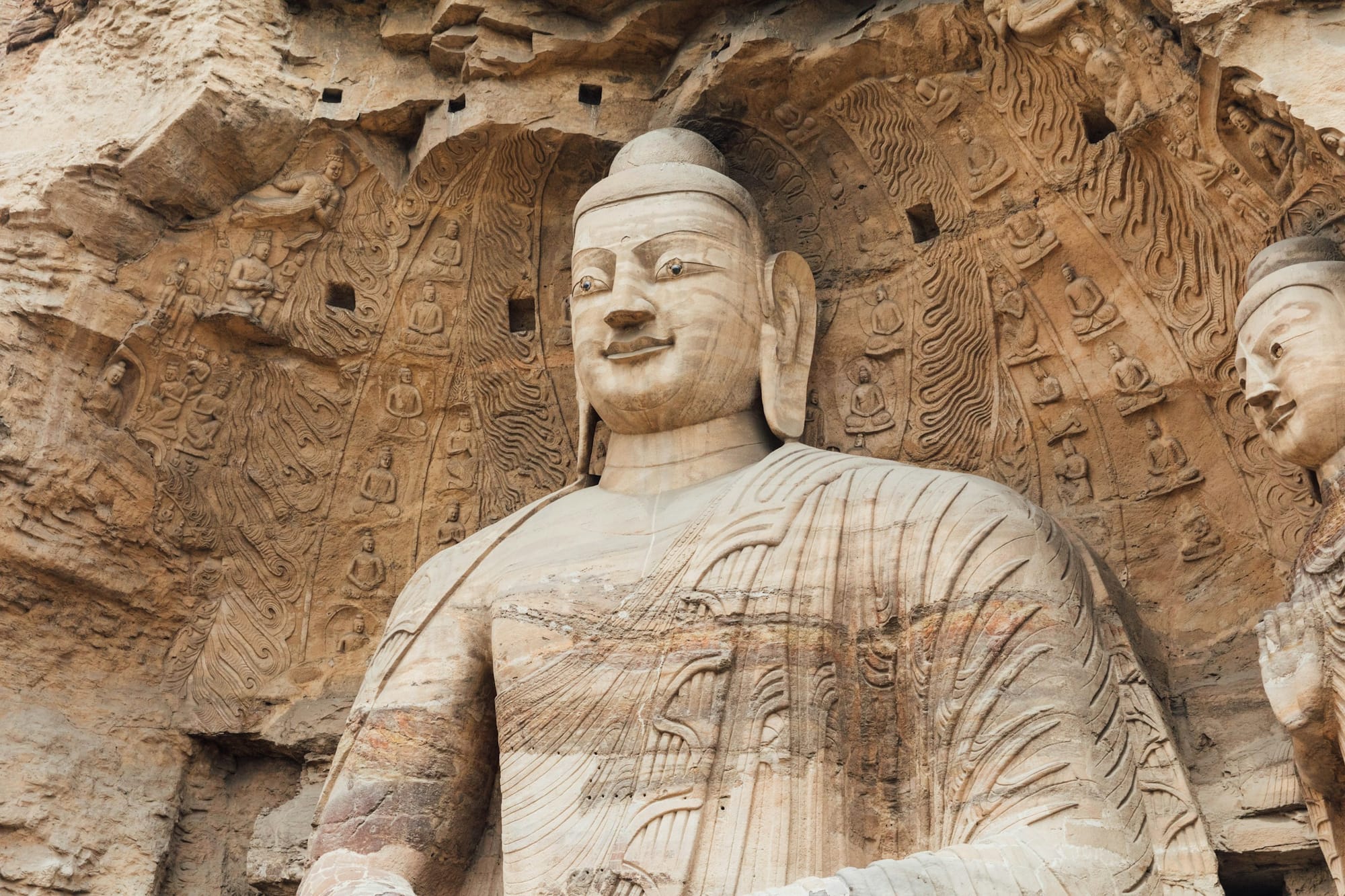 Sitzender Buddha aus Stein in einer Höhle der Yungang-Grotten bei Datong