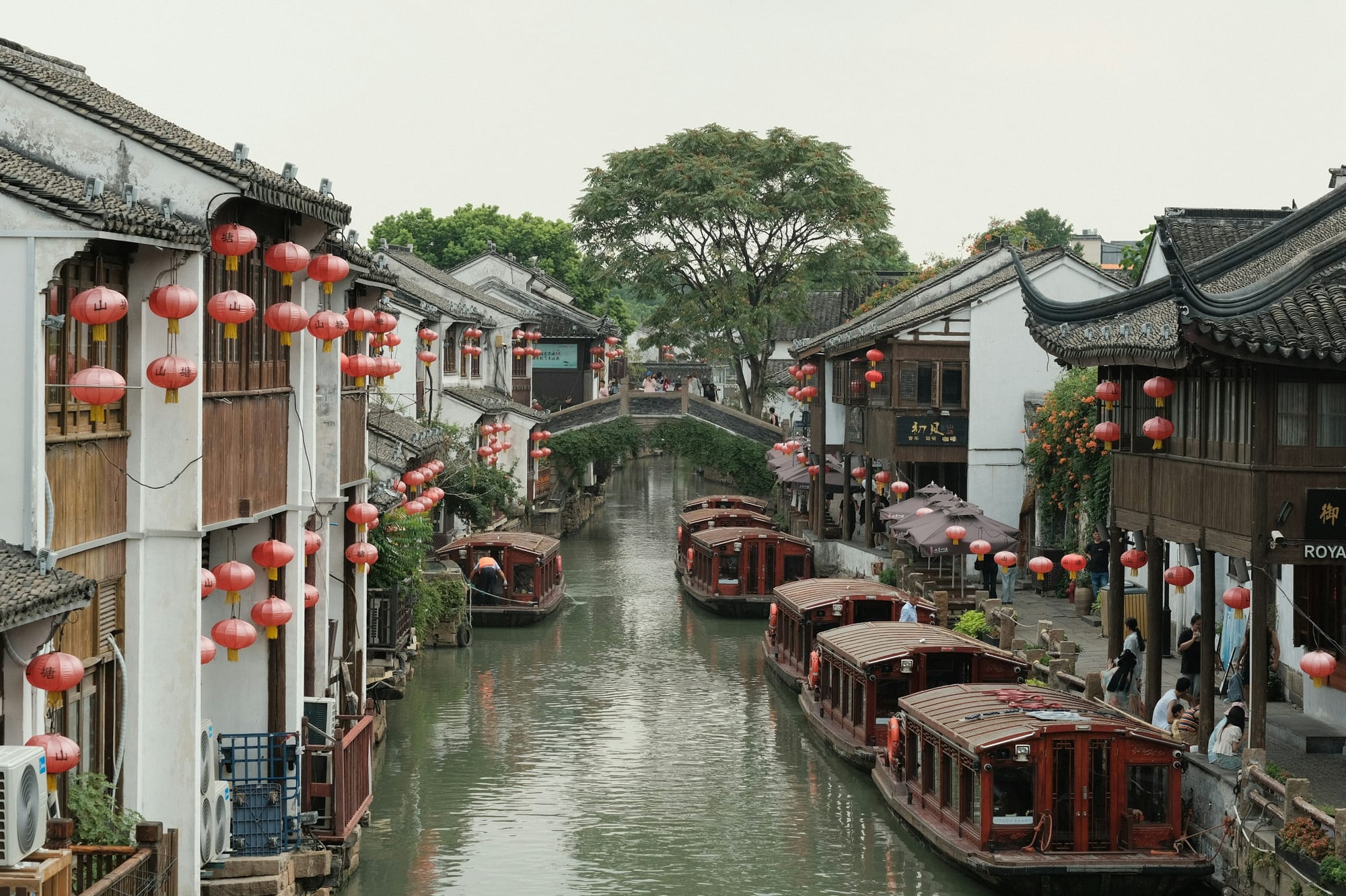 Barcos amarrados a lo largo de un canal bordeado de farolillos en Suzhou