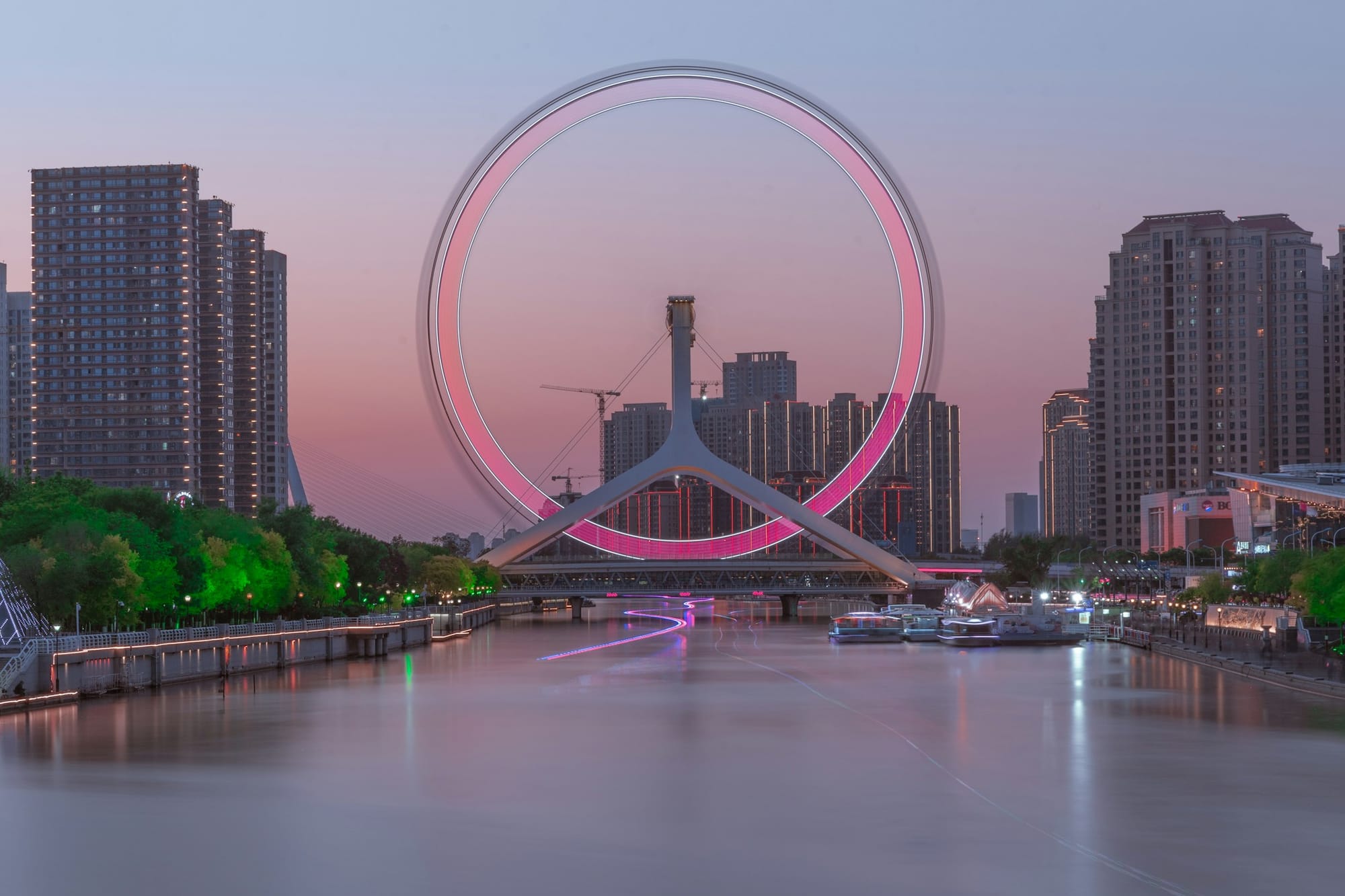 La ruota panoramica Tianjin Eye sul fiume Hai al crepuscolo