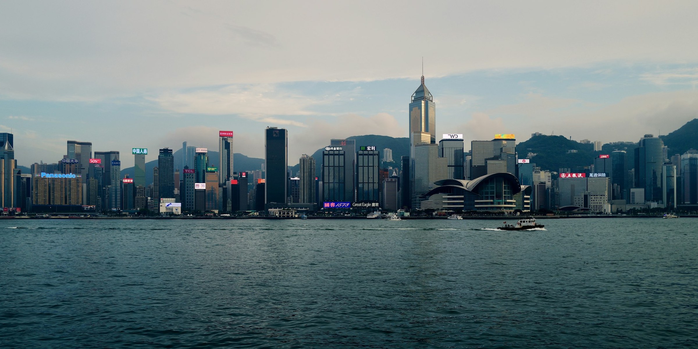 Skyline von Hong Kong Island über den Victoria Harbour von der Kowloon-Seite aus, mit dem Hafenwasser im Vordergrund
